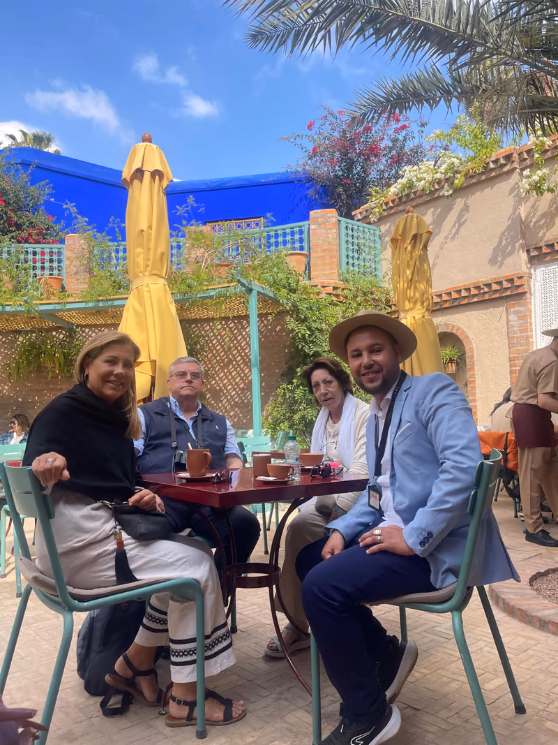 Guests and their guide relaxing in a blue Marrakech garden café